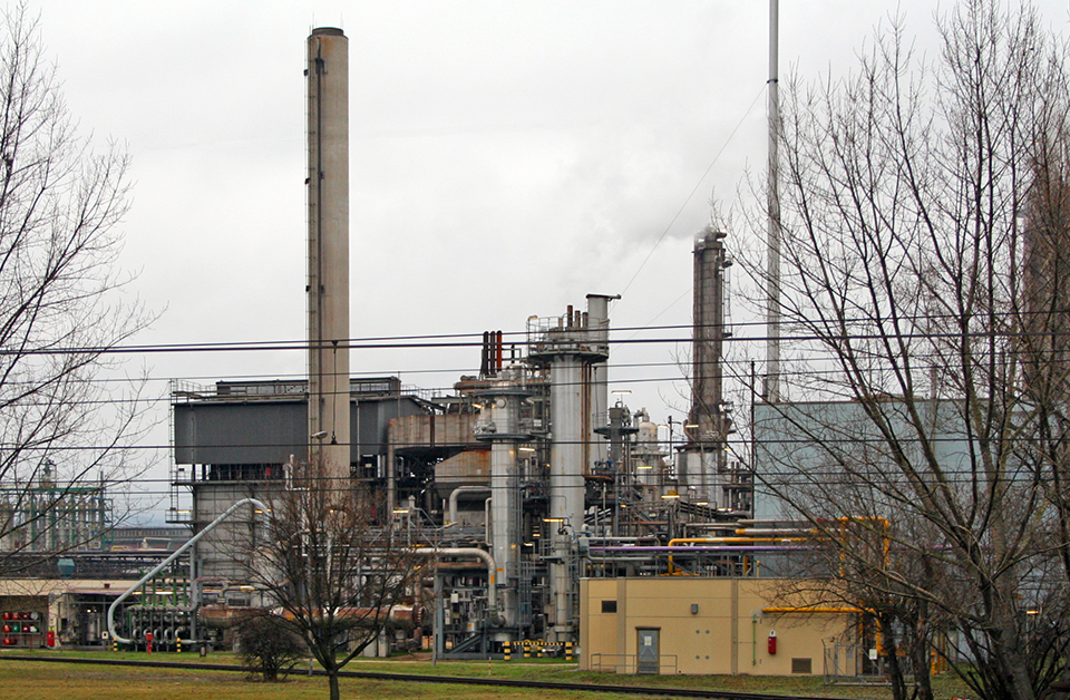 Eine Industrieanlage mit Schornsteinen und Rohren.