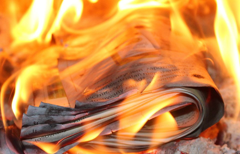 Abbildung von einer brennenden Zeitung.
