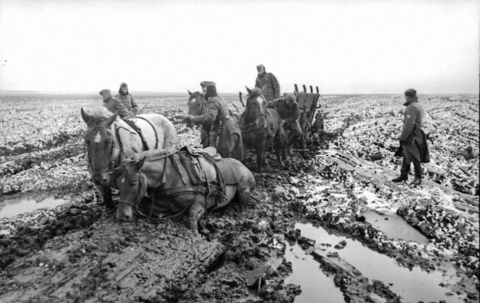 Ein schwarz-weiß Bild einer im Schlamm versinkenden Pferdekutsche auf einem aufgetauten Weg