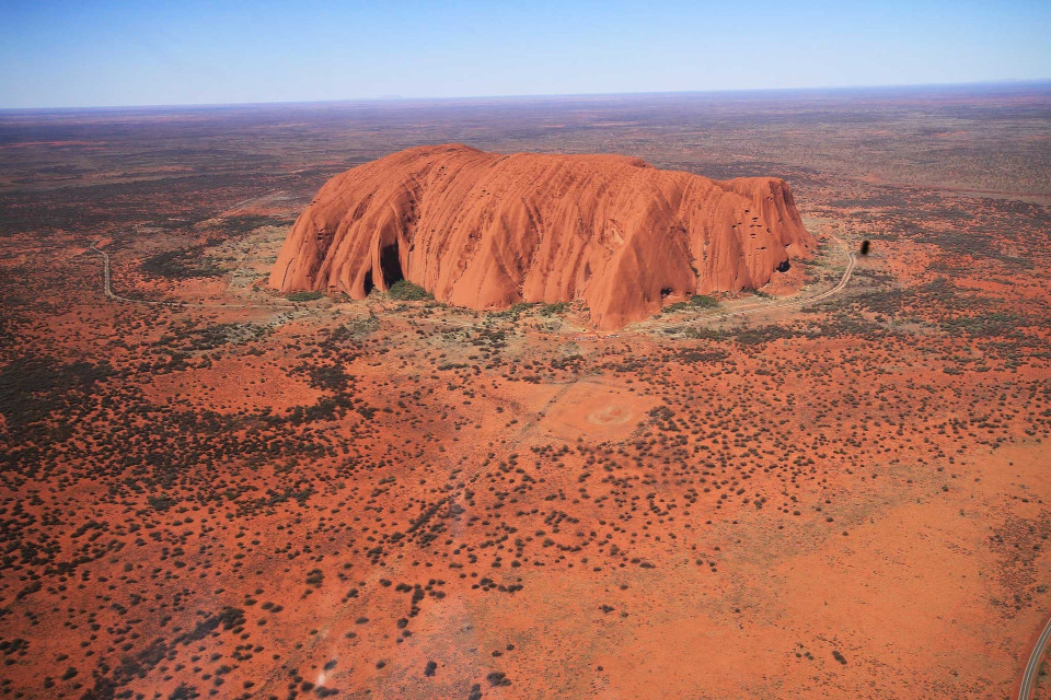 Flugaufnahme bei Tag, ein Roter Berg (Ayers-Rock) im Outback von Australien