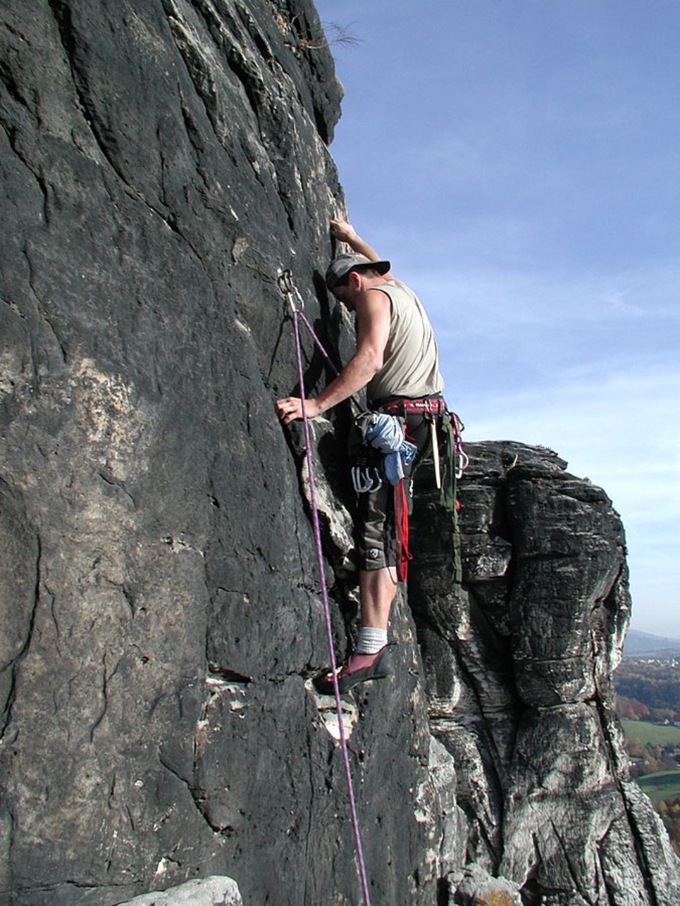 Kletterer mit einem Sicherunghaken an der Bergwand.