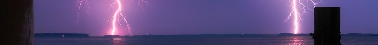 Blitze erleuchten ein Meer in der Nacht.